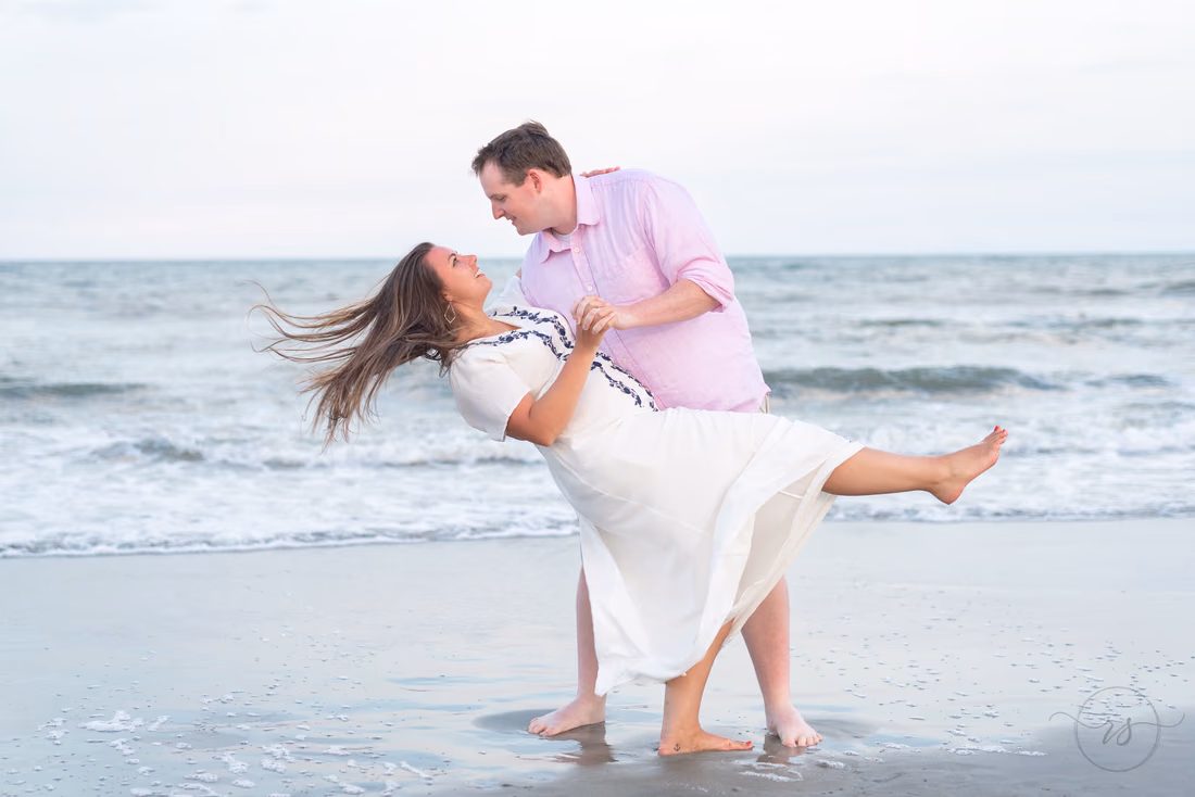 Husband dips his wife at the water's edge at Litchfield Beach