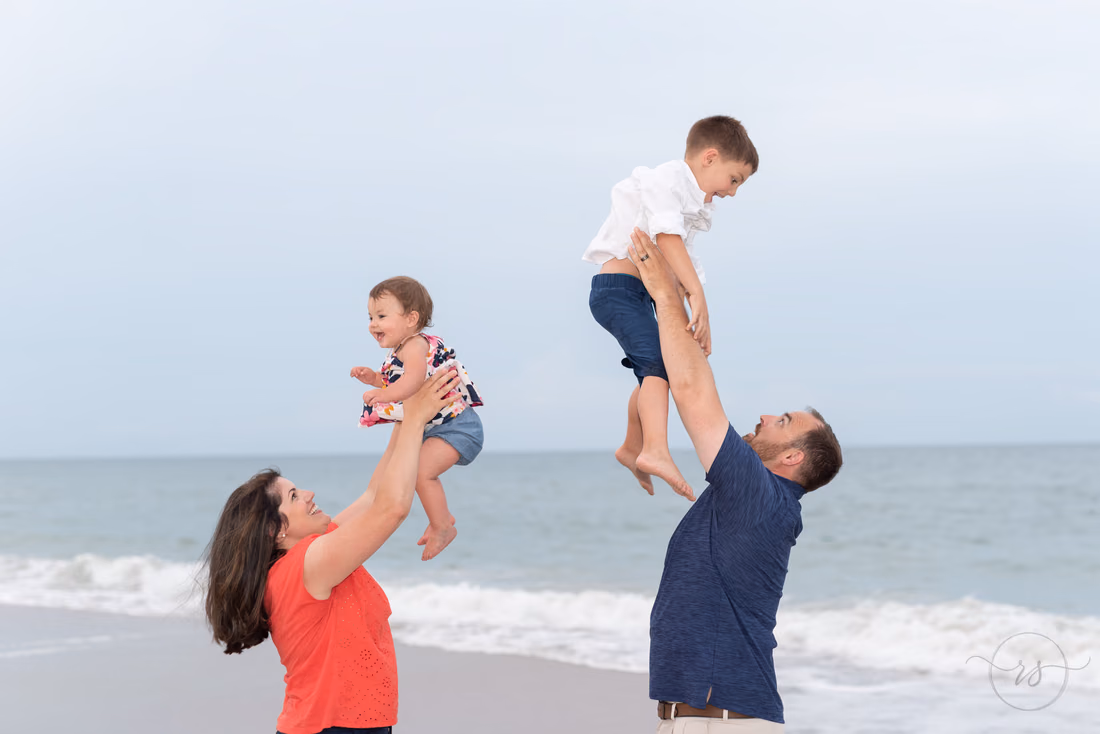 Mom and dad throwing kids in the air at the same time - Huntington Beach State Park