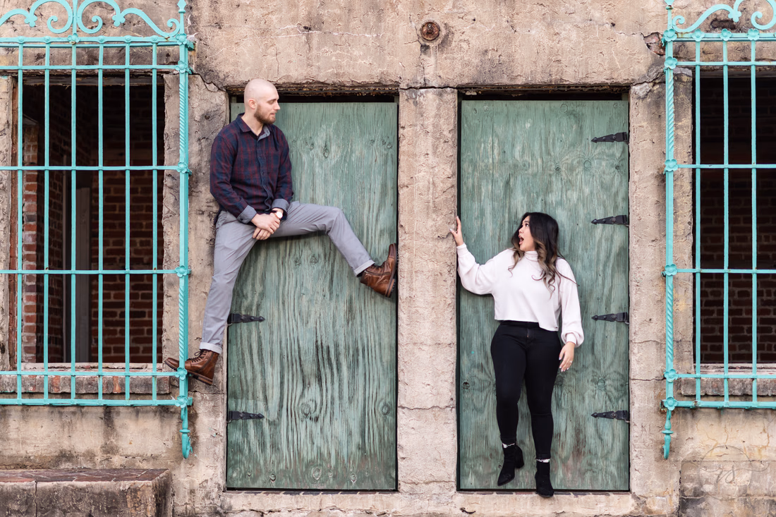 He props a foot up in one green castle doorway while she poses in the other at Huntington Beach State Park