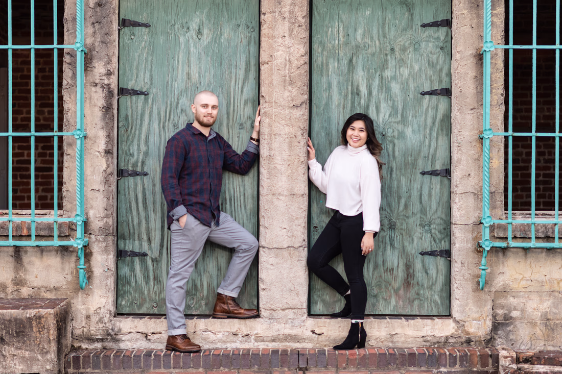 Couple standing in side-by-side green doorways of Atalaya Castle at Huntington Beach State Park