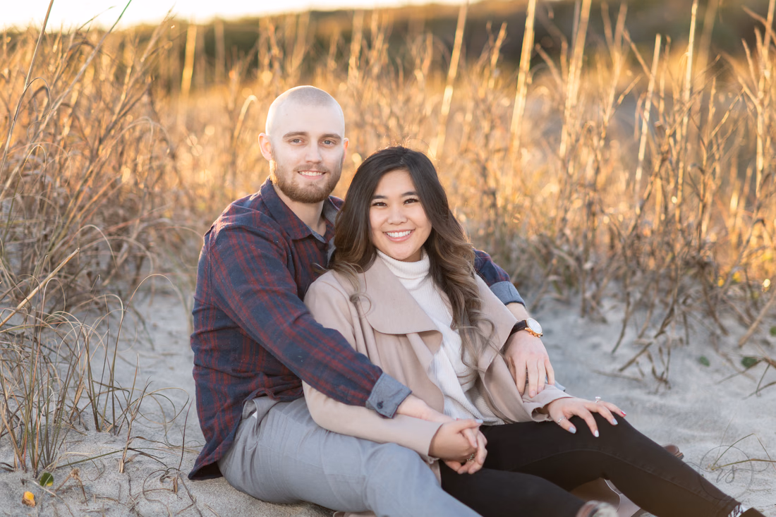 Couple sitting together in front of the sea oats - Huntington Beach State Park