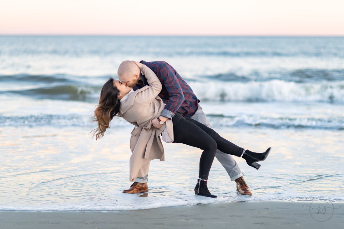 He dips her for a kiss in the shallow surf at Huntington Beach State Park