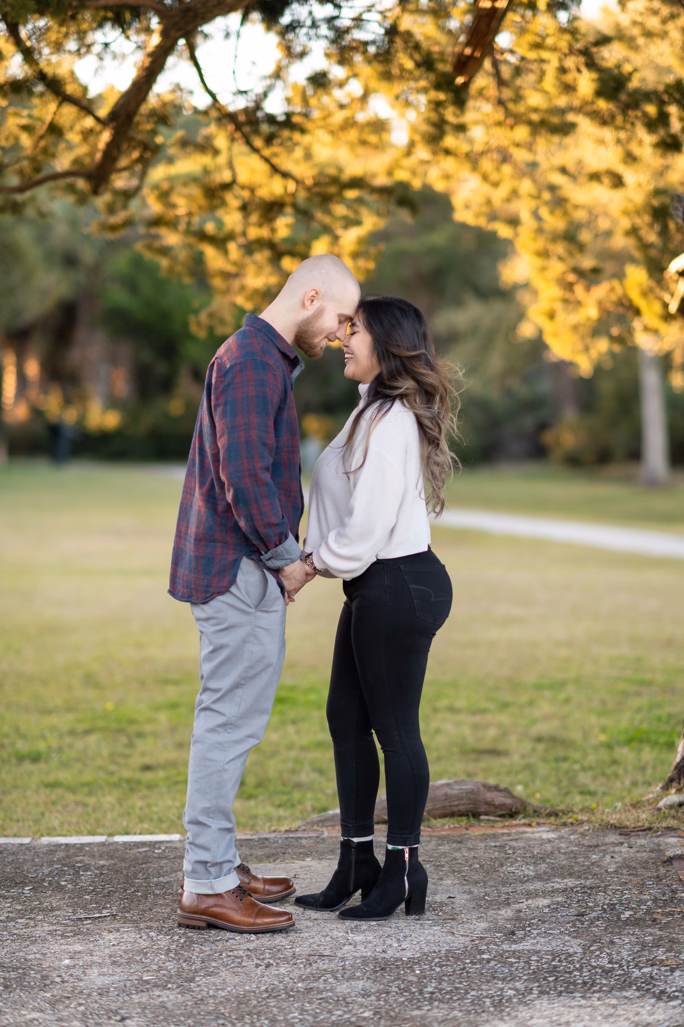 Couple touch foreheads under the old oaks at Huntington Beach State Park