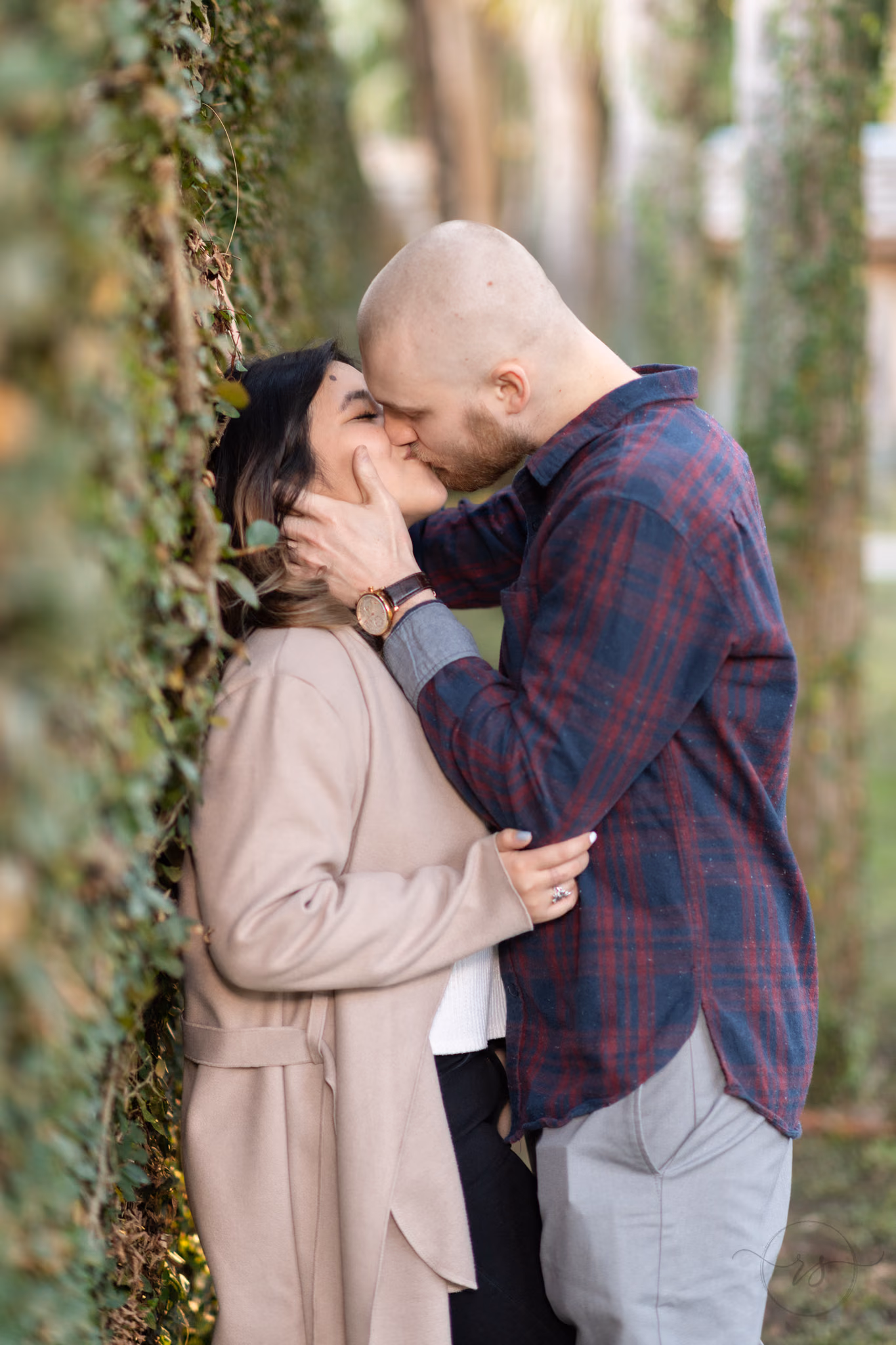 Couple kiss against the ivy-covered castle wall at Huntington Beach State Park