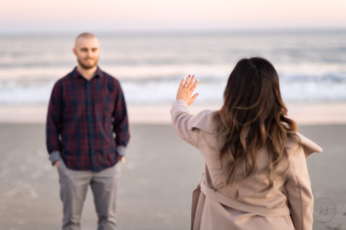 Showing off the ring with fiance in the background - Huntington Beach State Park