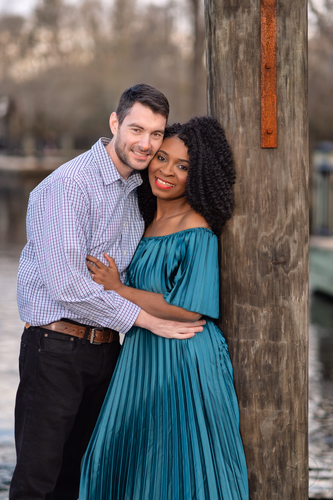 Couple smiling together beside a dock piling at the Conway Riverwalk