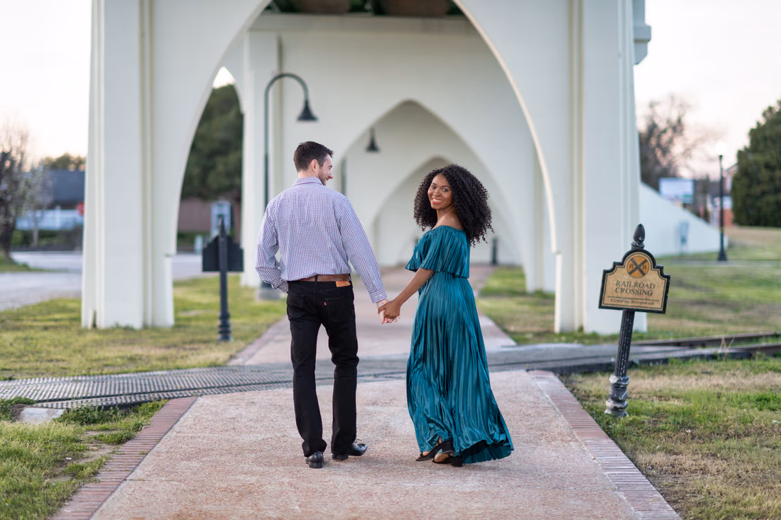 Holding hands walking under the old Conway bridge - Conway Riverwalk