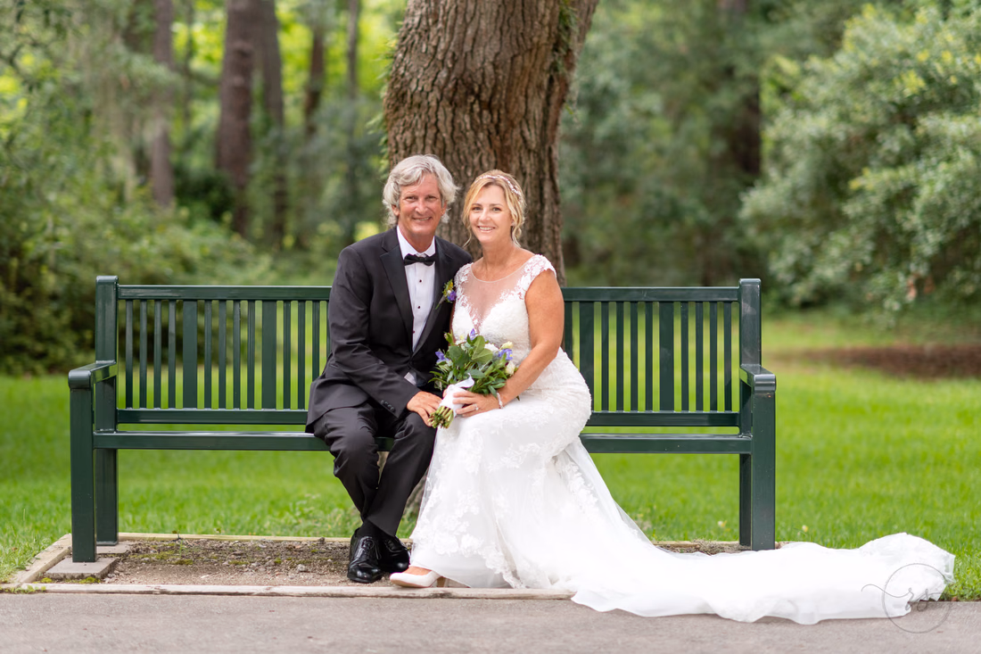 Bride and groom sitting on the park bench - Holiday Cottage - Brookgreen Gardens
