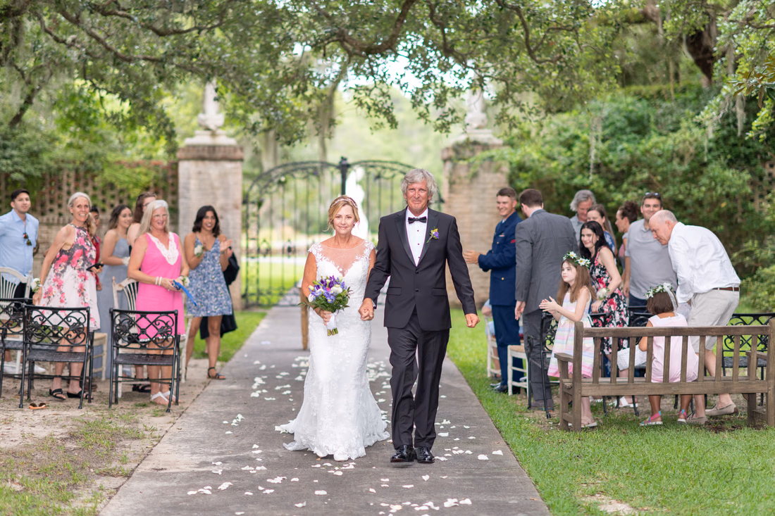 Bride and groom walking from the ceremony - Holiday Cottage - Brookgreen Gardens