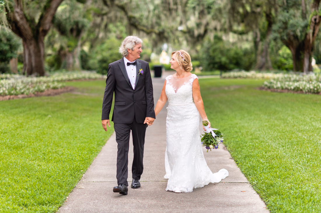 Bride and groom walking under the oaks - Live Oak Allee - Brookgreen Gardens