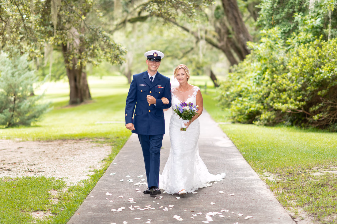 Groom's son walking bride down the garden path towards ceremony - Holiday Cottage - Brookgreen Gardens