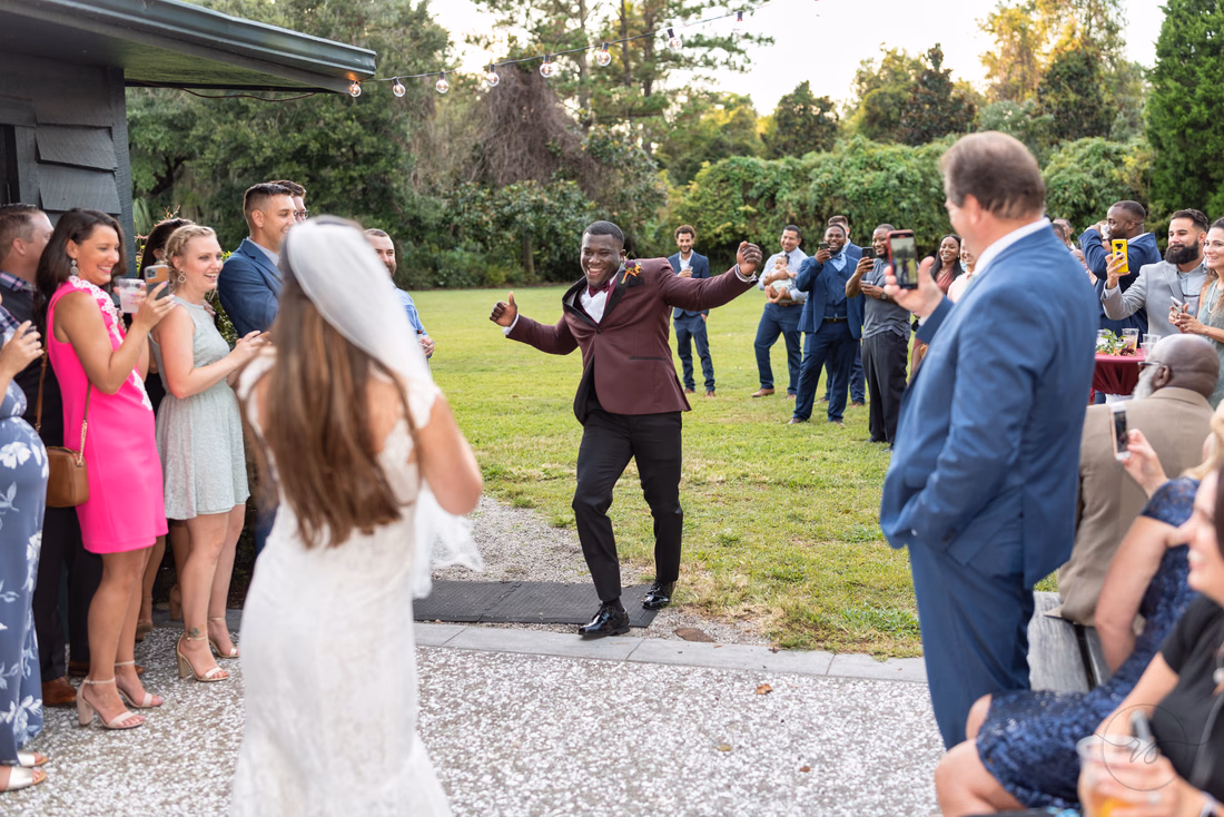 Groom dances into the reception as the bride follows at Magnolia Plantation