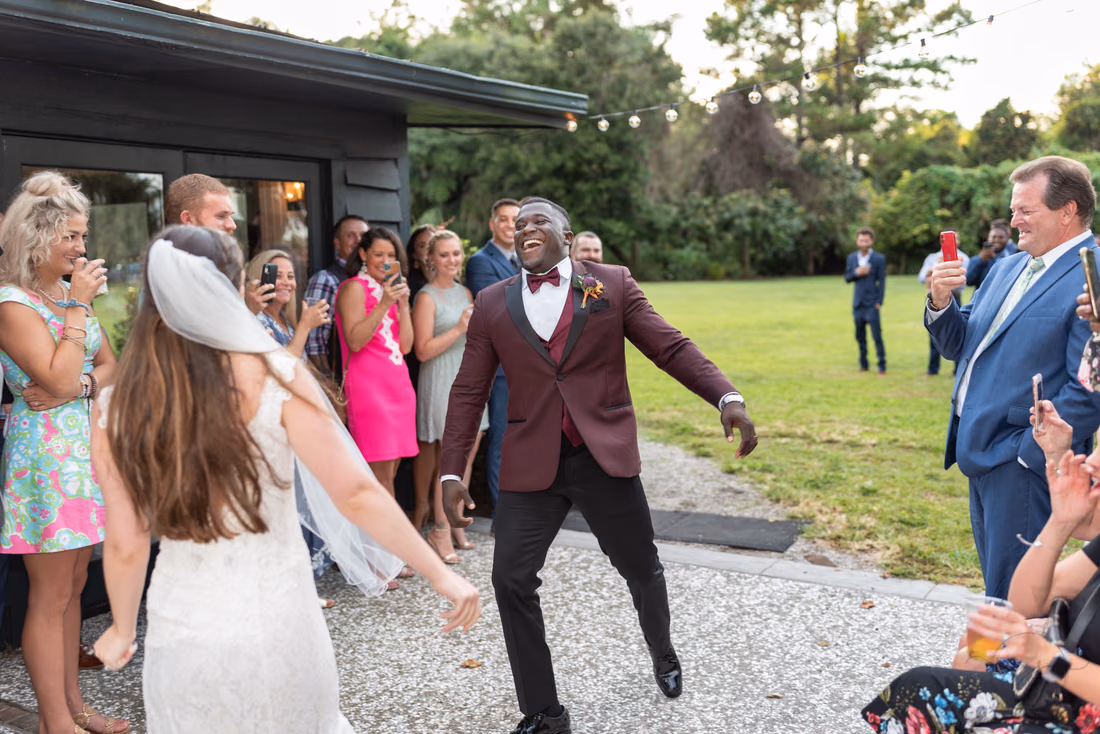 Groom dances toward the guests with the bride behind him at Magnolia Plantation