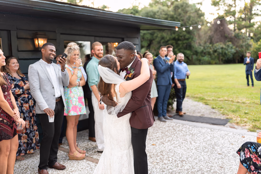 Bride and groom kiss after their entrance at the Carriage House reception at Magnolia Plantation