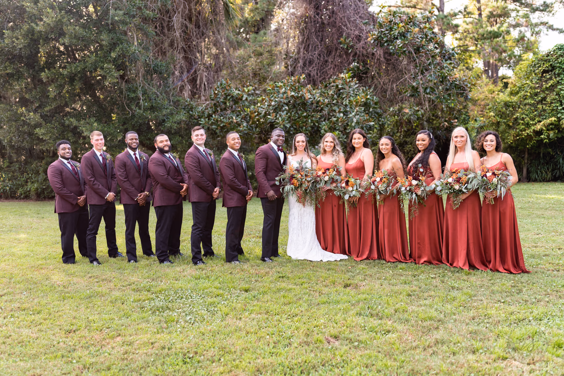 Bridal party lined up on the lawn in burgundy and rust at Magnolia Plantation