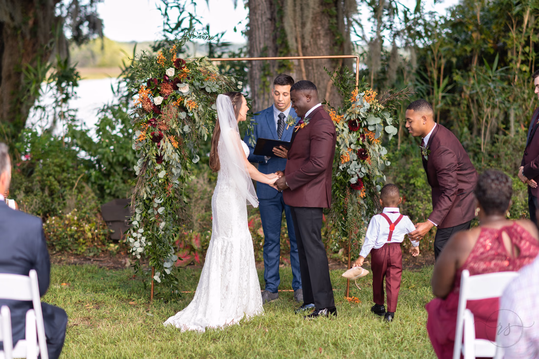 Bride and groom holding hands during ceremony - Magnolia Plantation - Charleston, SC