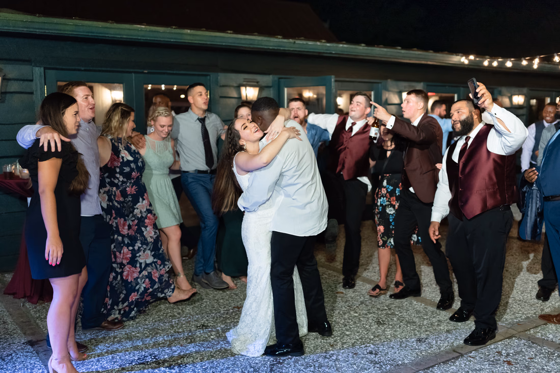 Bride and groom slow dance among guests at the end of the night at Magnolia Plantation