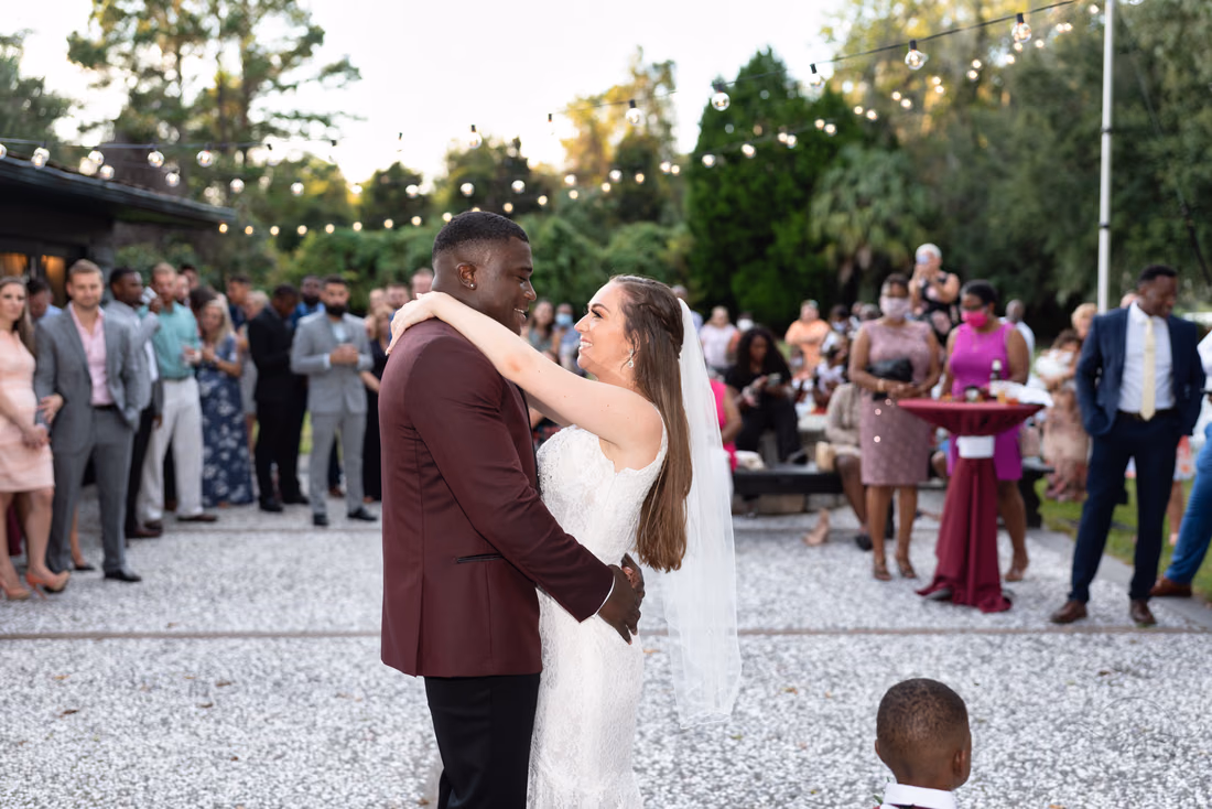 Bride and groom dance on the patio surrounded by guests at Magnolia Plantation