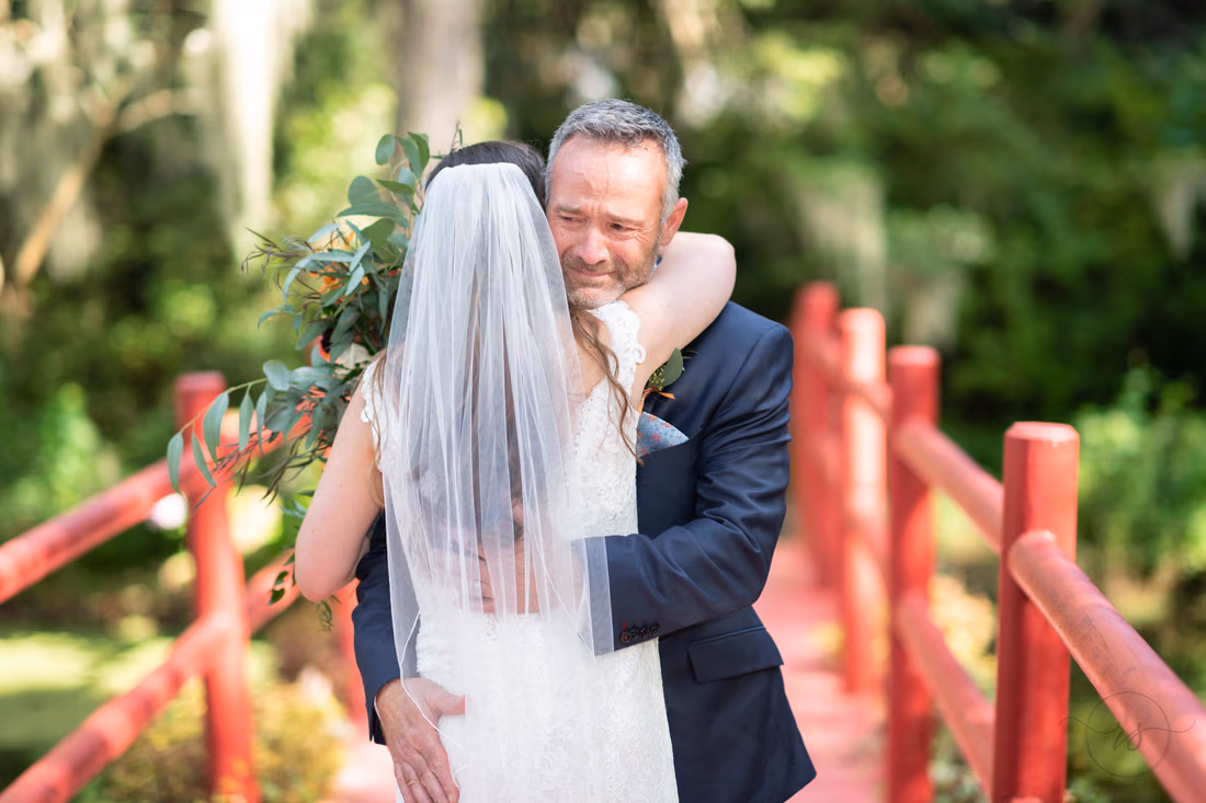 Bride and her father hug during their first look at Magnolia Plantation