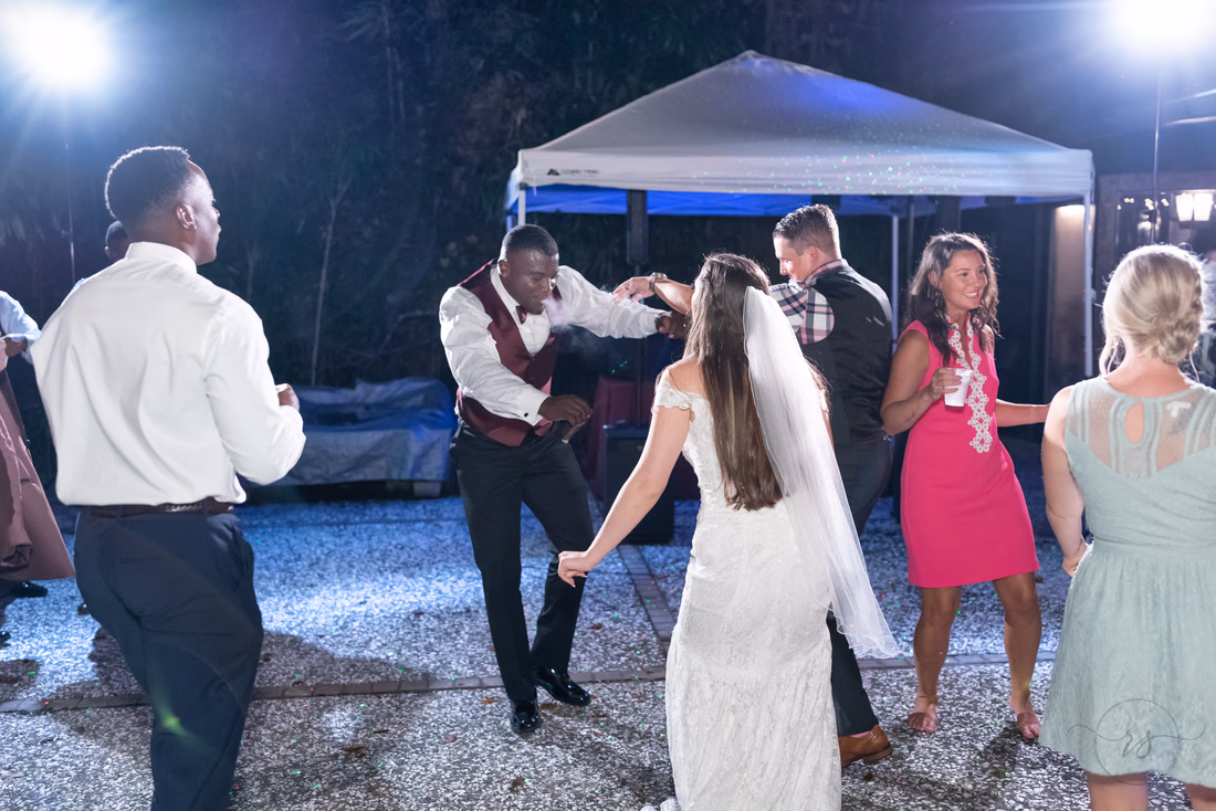 Bride and groom dance with guests at the outdoor reception at Magnolia Plantation