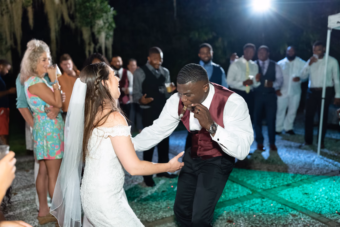 Groom laughs while dancing with the bride at the outdoor reception at Magnolia Plantation