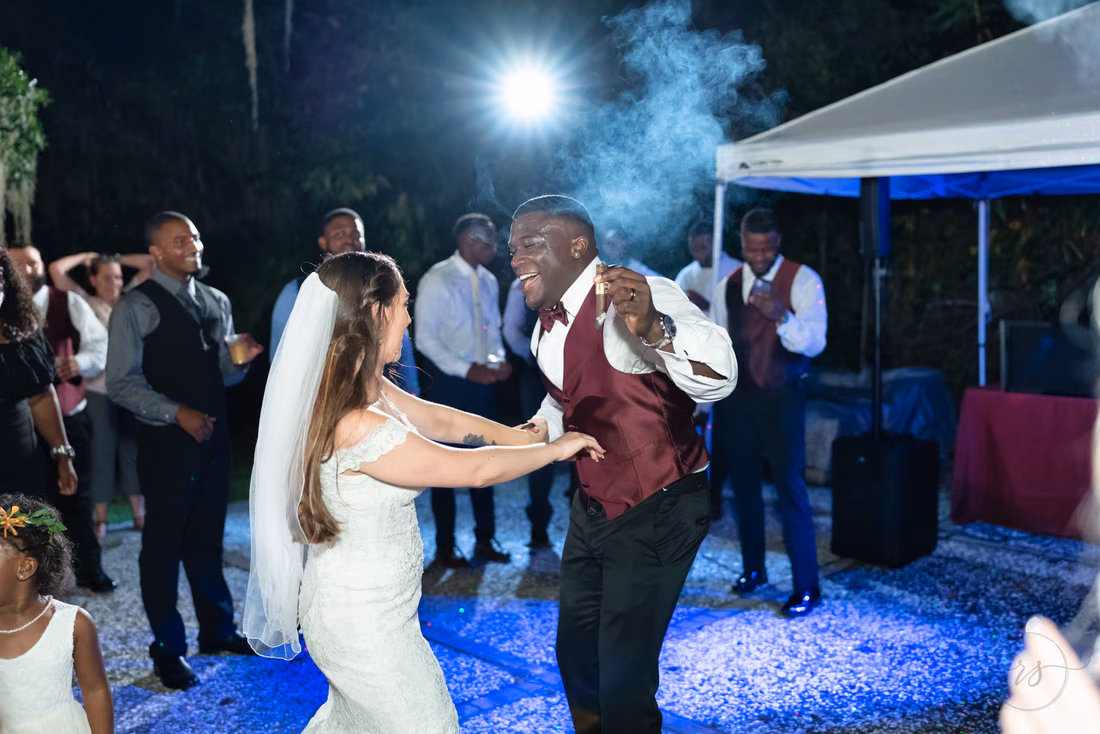 Bride and groom dance under the lights at the outdoor reception at Magnolia Plantation