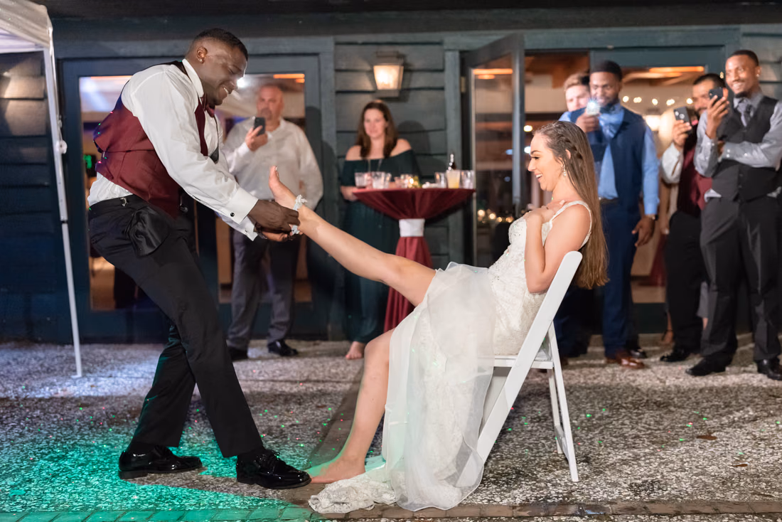 Groom removes the garter as guests laugh at Magnolia Plantation