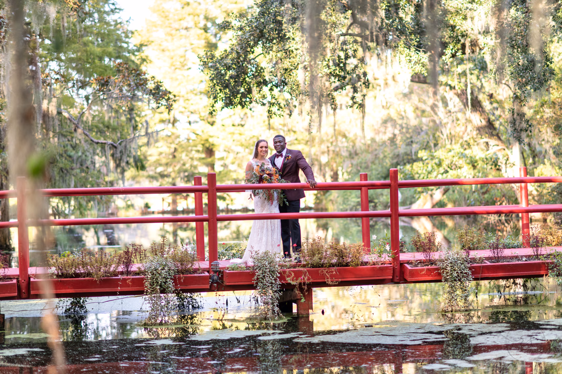 Portraits of bride and groom on the red bridge overlooking the lake - Magnolia Plantation - Charleston, SC