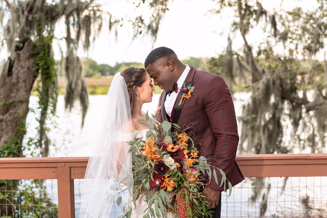 Bride and groom touch foreheads on the dock at sunset at Magnolia Plantation