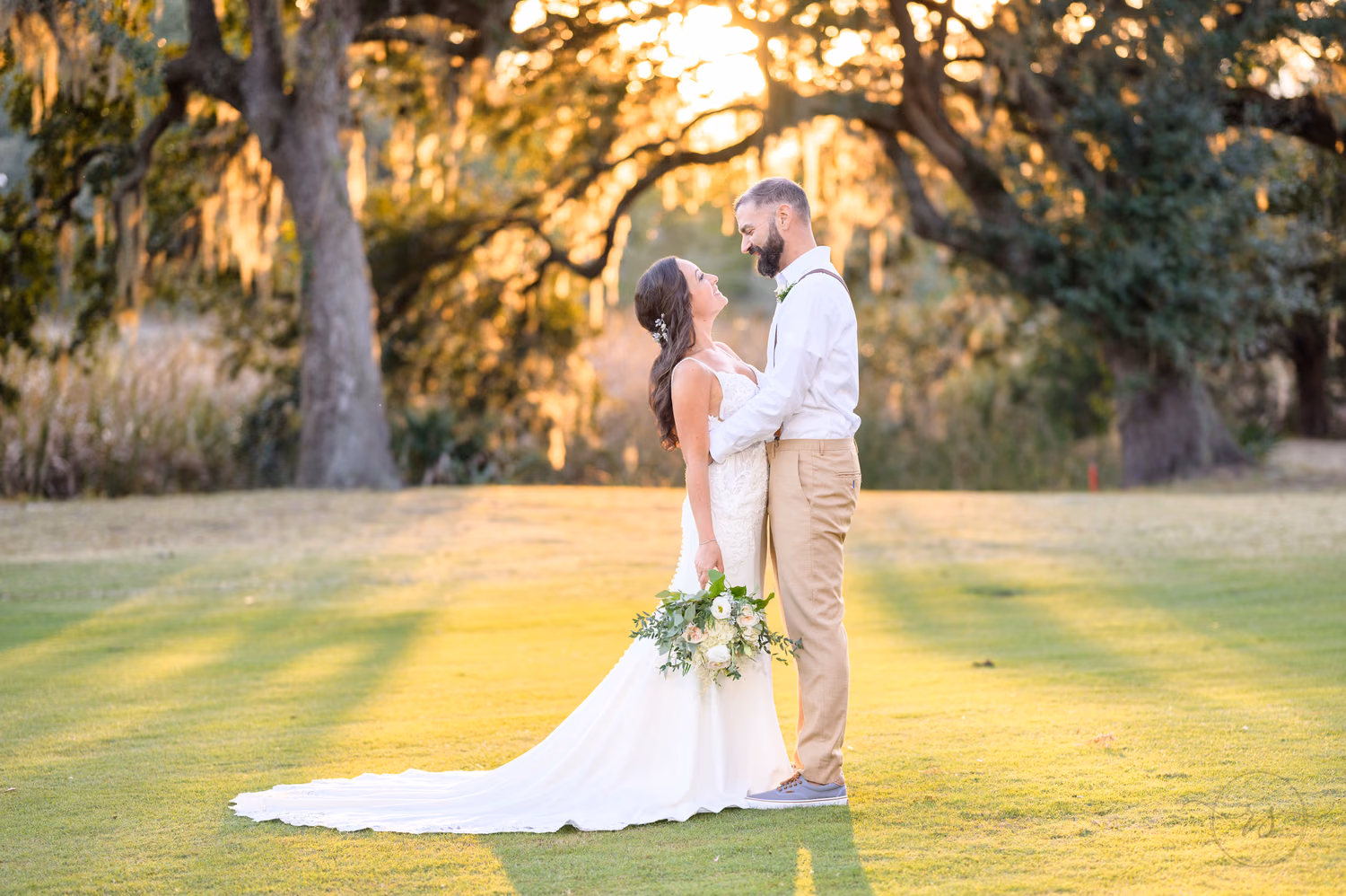 Bride and groom looking at each other framed by a old oak in the background - Pawleys Plantation