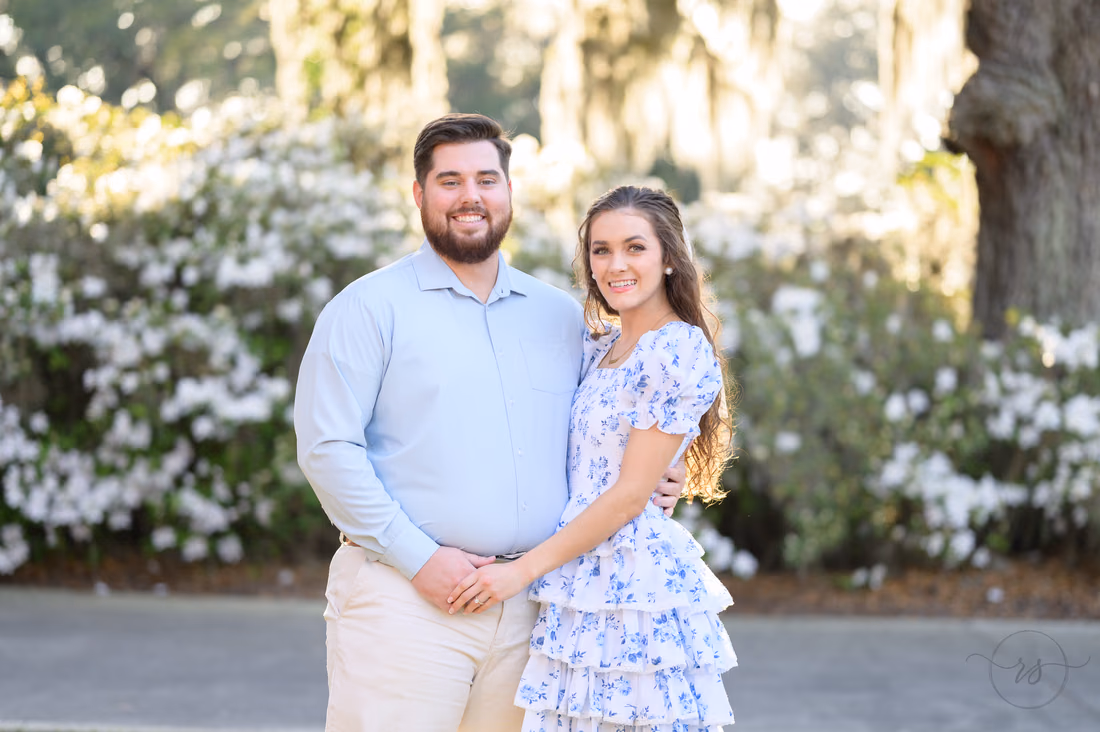 Engagement pictures in front of the white flowers - Caledonia Golf and Fish Club