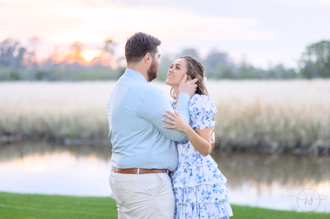 She brushes back her hair in his arms by the river at sunset at Caledonia Golf and Fish Club