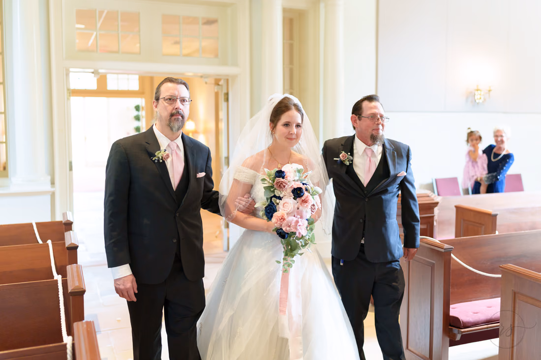 Closer view of the bride arm in arm with her escorts at the church doors - Christ Episcopal Church