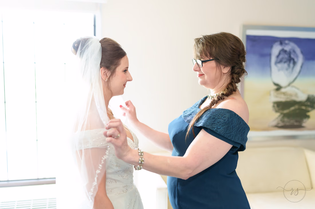 Bride's mother arranging the veil over her shoulders - Hotel Indigo