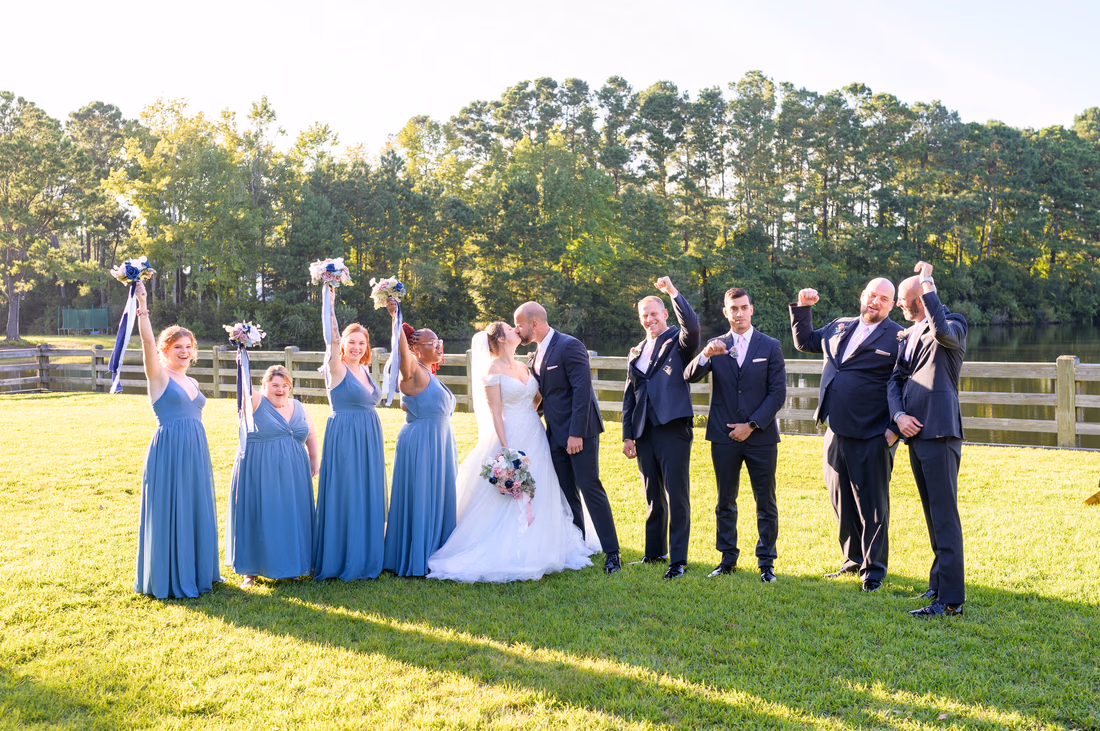 Cheers from the wedding party while bride and groom kiss - The Pavilion at Pepper Plantation