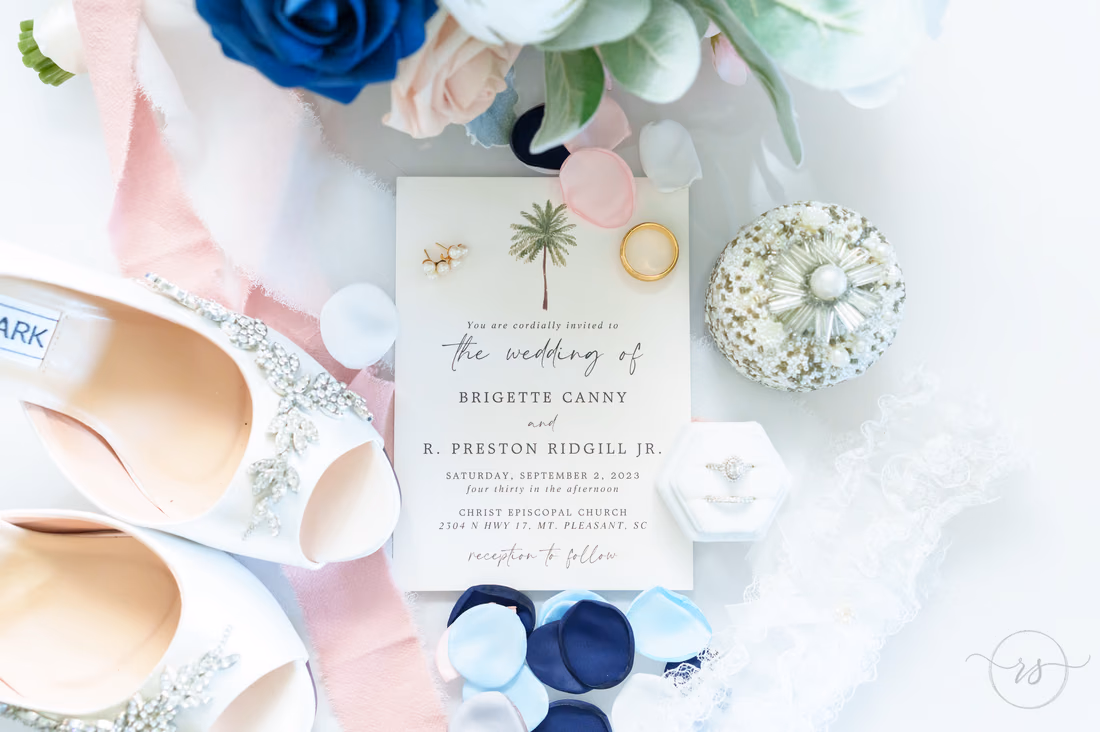 Wedding invitation, bridal shoes and ring box arranged with flowers - Hotel Indigo