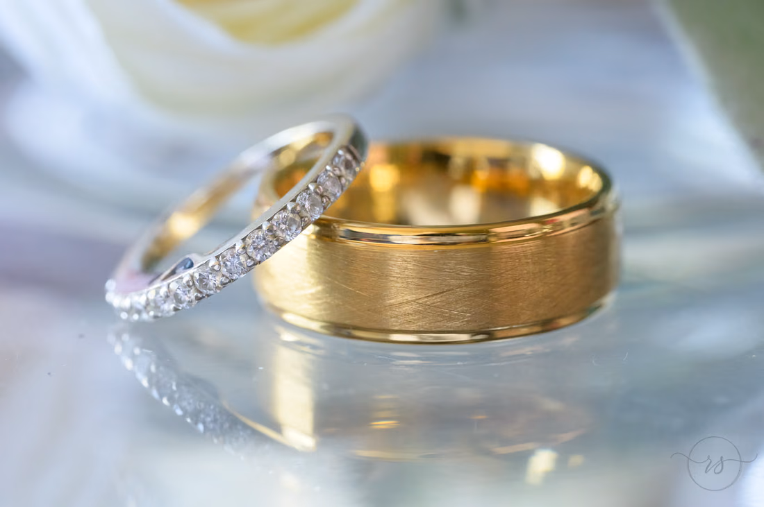 Diamond wedding band leaning on the groom's gold ring - Hotel Indigo