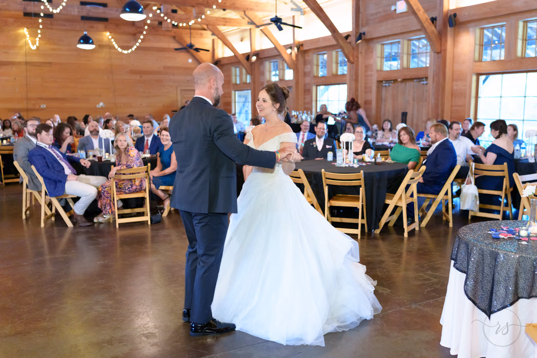 Bride and groom holding hands during their first dance in the reception hall - The Pavilion at Pepper Plantation