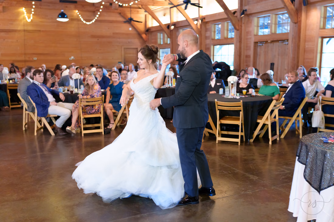 Bride's dress swirling as the groom spins her during the first dance - The Pavilion at Pepper Plantation