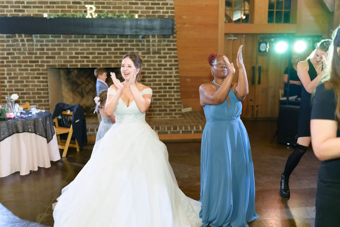 Bride and a bridesmaid clapping along on the dance floor - The Pavilion at Pepper Plantation