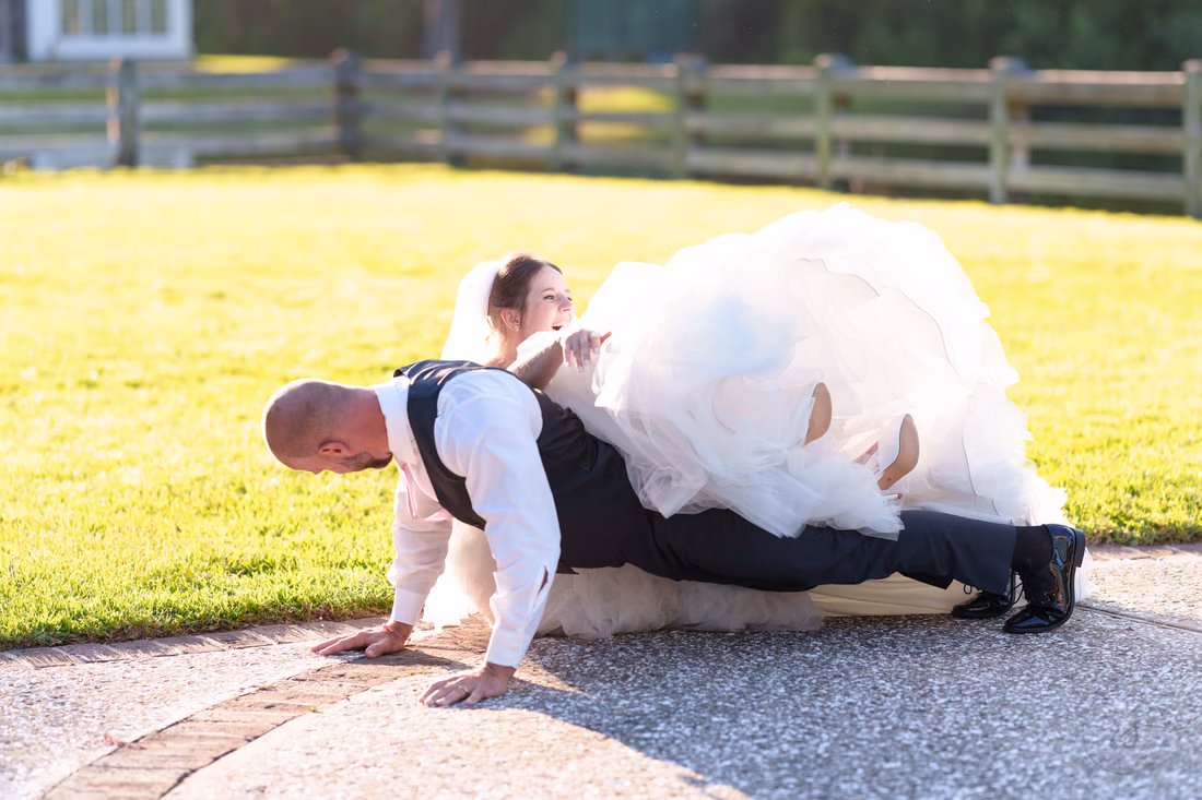 Groom doing a pushup with the bride lying across his back - The Pavilion at Pepper Plantation