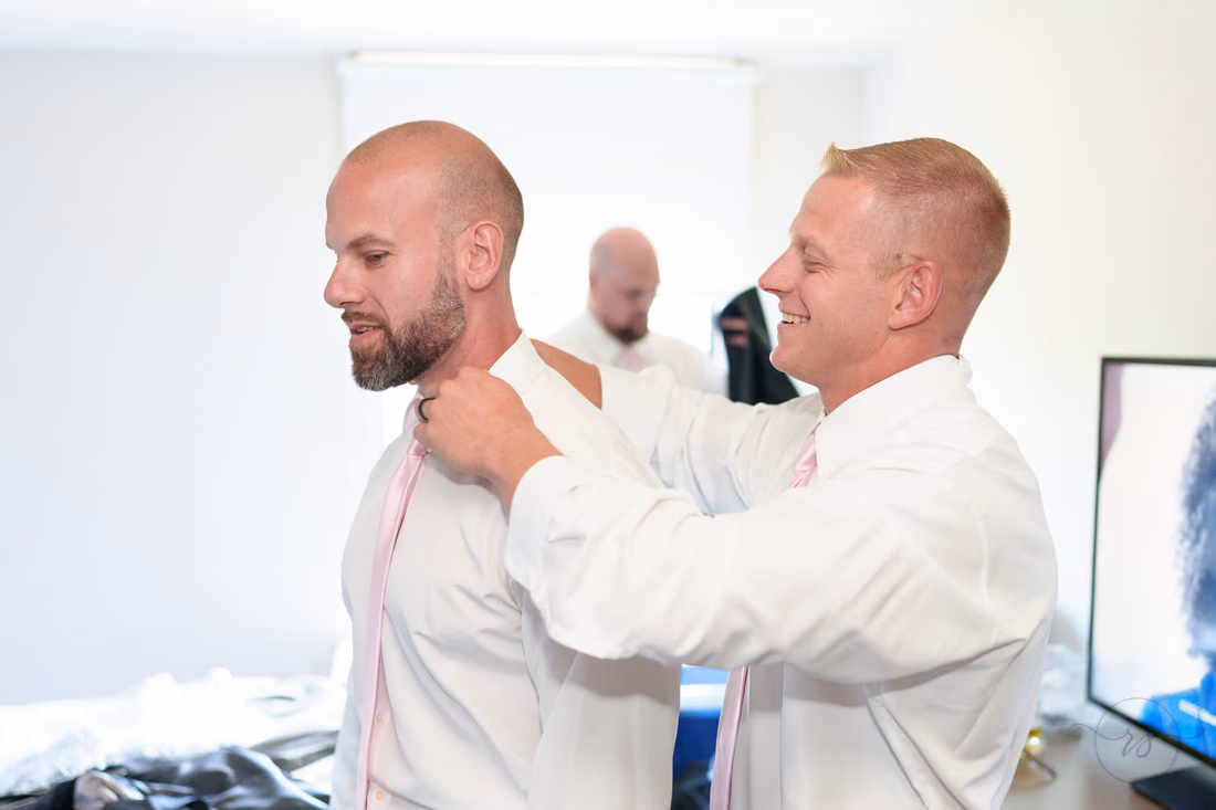 Groomsman helping the groom with his collar - Hotel Indigo