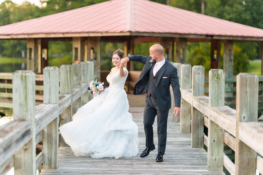 Bride's dress flaring as she spins on the gazebo boardwalk - The Pavilion at Pepper Plantation