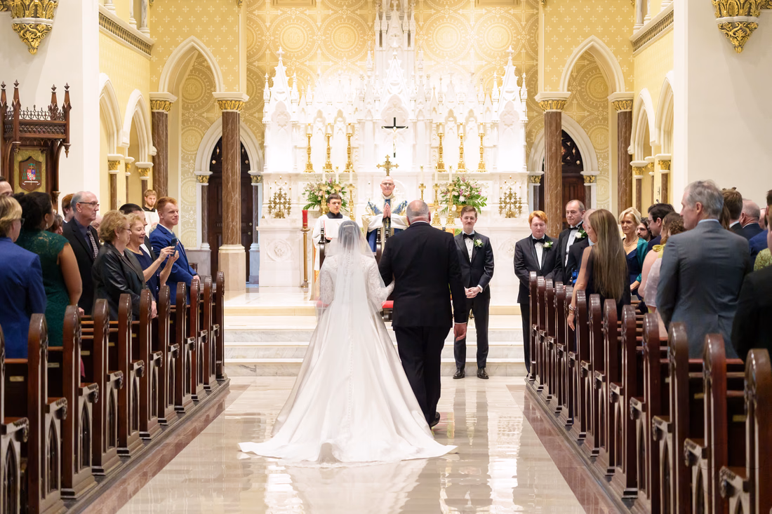 Bride and father walking toward the altar, seen from behind - Cathedral of Saint John Charleston