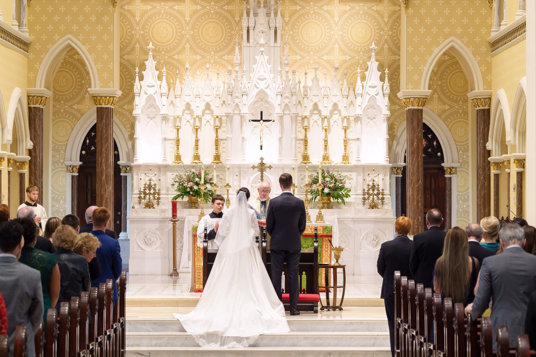 Bride and groom at the altar, seen from the back of the cathedral - Cathedral of Saint John Charleston