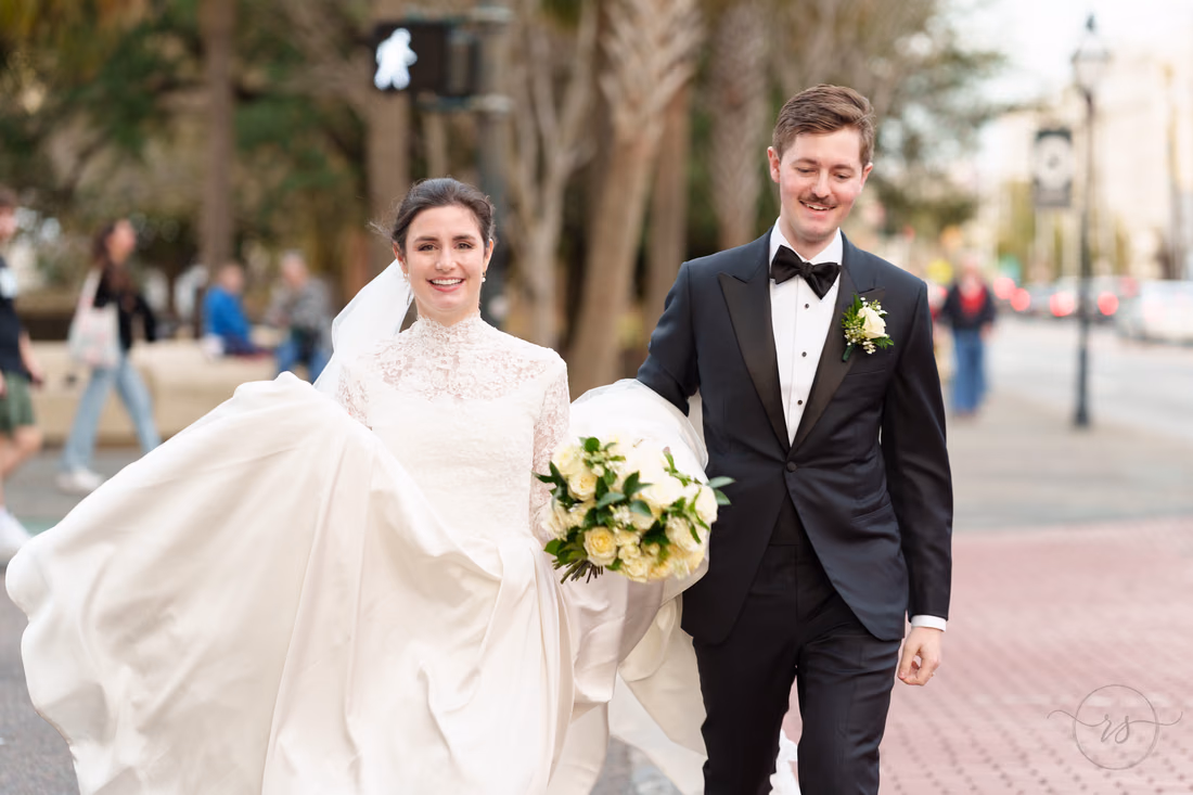 Bride and groom laughing as they hurry across the crosswalk - Marion Square Charleston