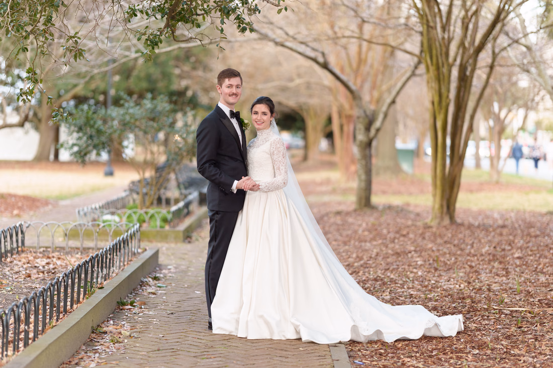 Bride and groom standing together on the brick walkway in the park - Marion Square Charleston