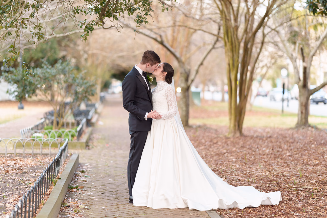 Bride and groom kissing on the walkway in the park - Marion Square Charleston