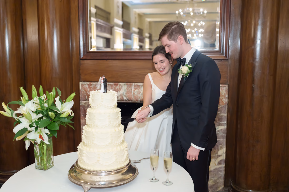 Bride and groom cutting the cake by the fireplace - Francis Marion Charleston