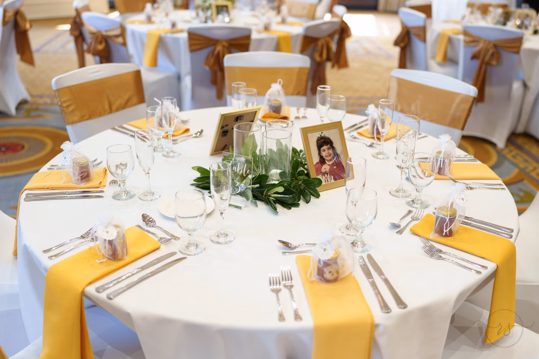 Round table with gold napkins and a framed childhood photo - Francis Marion Charleston